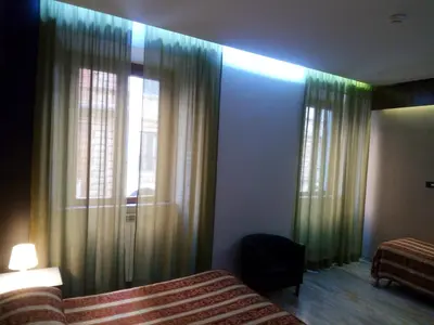 a bedroom with a bed and a window with curtains at Hotel Milazzo Roma in Rome
