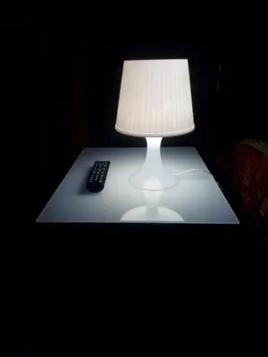 a table with a lamp and a remote control on it at Hotel Milazzo Roma in Rome