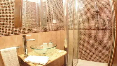 a bathroom with a glass bowl sink and a shower at La Piazzetta di Roma in Rome