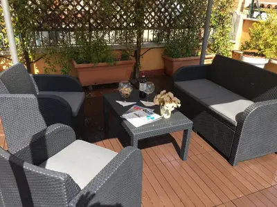 a patio with two couches and a table and chairs at La Piazzetta di Roma in Rome