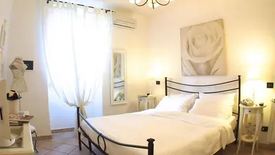 a bedroom with a bed and a painting on the wall at La Piazzetta di Roma in Rome