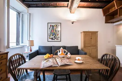 a dining room with a wooden table and a couch at Dell'Orso Residence in Rome