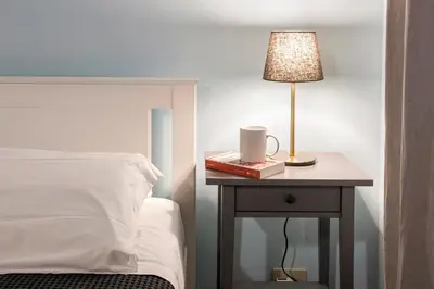 a bed and a table with a lamp on a night stand at Dell'Orso Residence in Rome