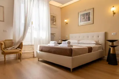 a bedroom with a bed and a chair and a window at Sant'Ivo Apartments in Rome