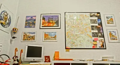 a wall with a computer monitor and a map and pictures at Gite House in Rome
