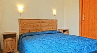 a bedroom with a blue bed with two lights on top at Gite House in Rome