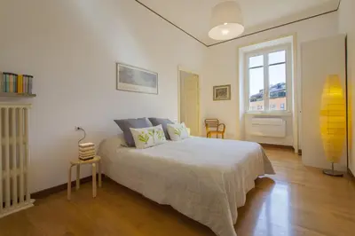 a bedroom with a bed and a window and a surfboard at Vatican Suite Carolina Holiday Apartment in Rome