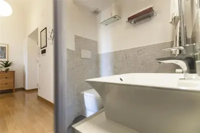 a white dining room with a white table and white chairs at Vatican Suite Carolina Holiday Apartment in Rome