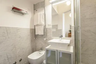 a white bathroom with a sink and a shower at Vatican Suite Carolina Holiday Apartment in Rome