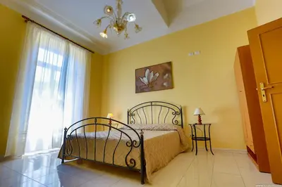 a bedroom with a bed and a window and a chandelier at Gordon's Apartment in Rome