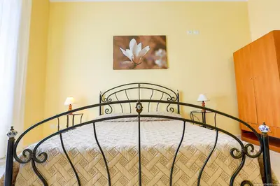 a bedroom with a black bed with a flower on the wall at Gordon's Apartment in Rome
