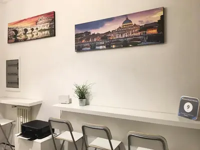 a waiting room with chairs and posters on the wall at Roema Guest House in Rome