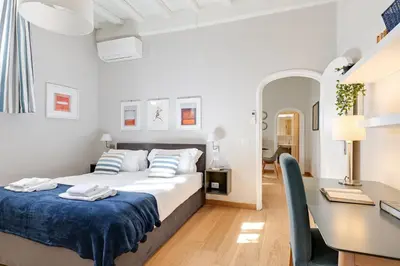 a white bedroom with a bed and a desk at Rome as you feel - Grotta Pinta apartments in Rome