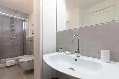 a white bathroom with a sink and a toilet at Rome as you feel - Grotta Pinta apartments in Rome