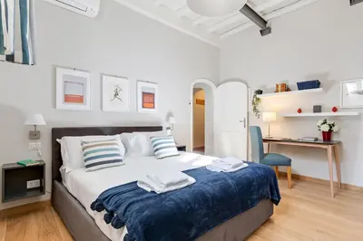 a bedroom with a large bed with a blue blanket at Rome as you feel - Grotta Pinta apartments in Rome