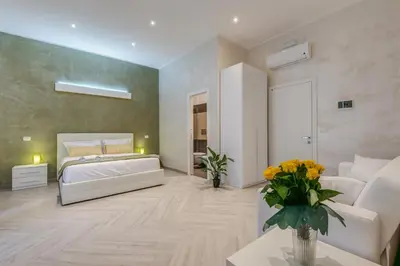 a bedroom with a white bed and a couch at Penta Luxury House in Rome