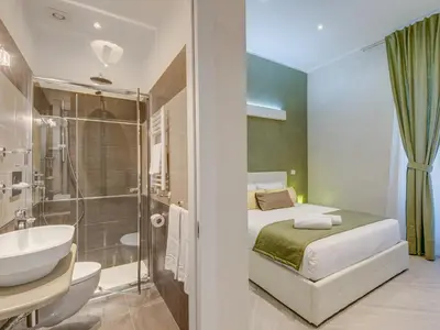 a bathroom with a bed and a shower and a sink at Penta Luxury House in Rome