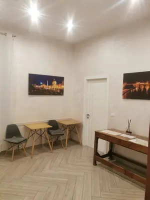 a room with two tables and chairs and a painting on the wall at Penta Luxury House in Rome