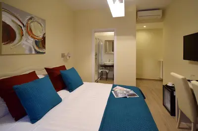 a bedroom with a bed with blue and red pillows at CdR Guest House in Rome