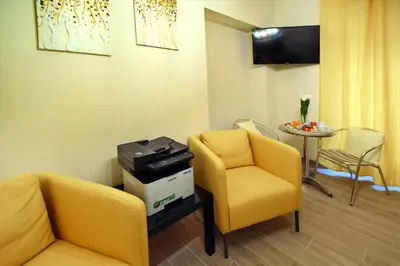 a waiting room with yellow chairs and a table at CdR Guest House in Rome