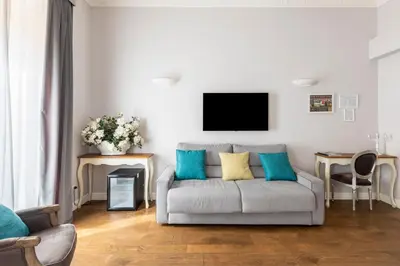 a living room with a couch and a tv on the wall at Spagna Art & Suites - CA Domus Collection in Rome
