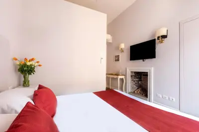 a bedroom with a white bed and a fireplace at Spagna Art & Suites - CA Domus Collection in Rome