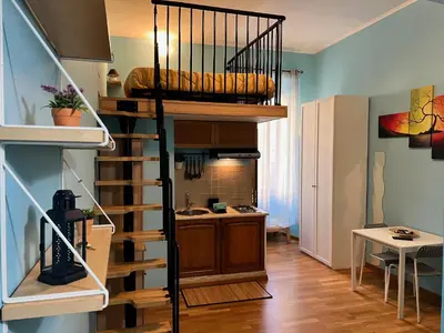 a loft bed in a room with a kitchen at MoonLight Suite in Rome