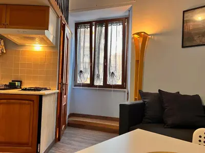 a living room with a couch and a kitchen at MoonLight Suite in Rome
