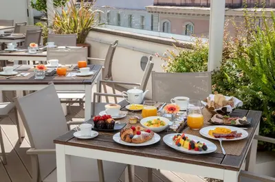 a table with breakfast food on a balcony at The Glam in Rome