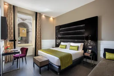 a hotel room with a large bed and a chair at The Glam in Rome
