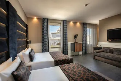 a hotel room with two beds and a couch at The Glam in Rome