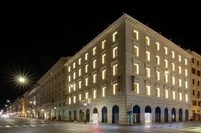 a lit up building on a street at night at The Glam in Rome
