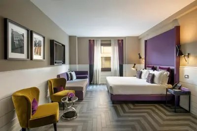 a hotel room with a bed and a couch at The Tribune, part of JdV by Hyatt in Rome