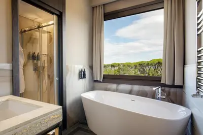 a bathroom with a large white tub and a window at The Tribune, part of JdV by Hyatt in Rome