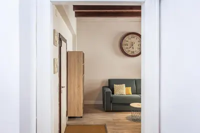 a living room with a couch and a clock on the wall at Piazza Navona Lovely Apartment in Rome