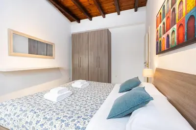 a bedroom with a bed with blue pillows at Piazza Navona Lovely Apartment in Rome