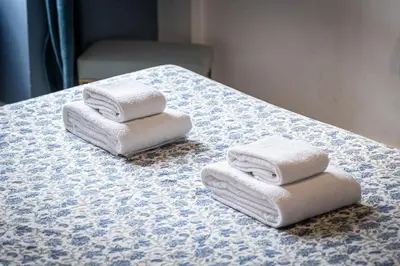 three towels are stacked on a blue and white table at Piazza Navona Lovely Apartment in Rome