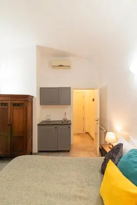 a bedroom with a bed and a kitchen in it at La Casa Di Amy in Rome