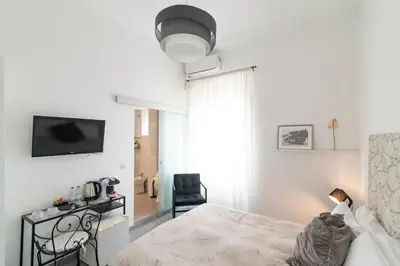a bedroom with a bed and a television and a chair at La Casa Di Amy in Rome