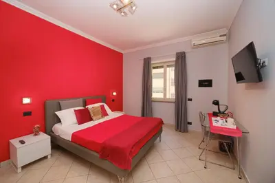 a red bedroom with a bed and a television at Midnight in Vatican in Rome