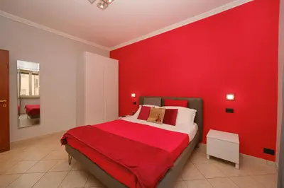 a red bedroom with a bed with a red wall at Midnight in Vatican in Rome