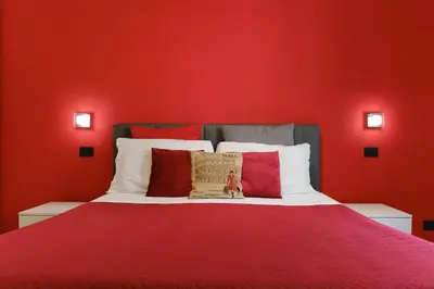 a red bedroom with a bed with red walls at Midnight in Vatican in Rome