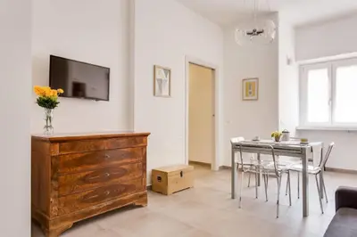 a living room with a table and a tv on a wall at Franca's Home in Rome