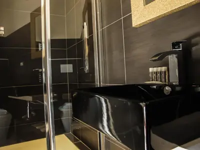 a bathroom with a black tub and a shower at Roma Veneto Relais in Rome