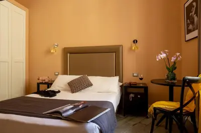 a hotel room with a bed and a table with flowers at My Trevi Charming & Luxury Rooms in Rome