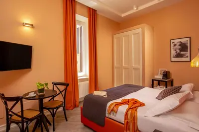 a bedroom with a bed and a table and a television at My Trevi Charming & Luxury Rooms in Rome