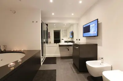 a bathroom with a sink toilet and a tv on the wall at Sant'Angelo Exclusive Spacious Art in Rome