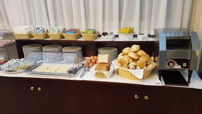 a buffet with plates and baskets of food and a microwave at Hotel Best Roma in Rome