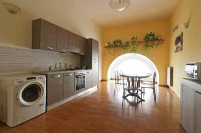 a kitchen with a table and a washing machine at Roman House in Rome
