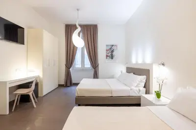 a hotel room with two beds and a desk at Maison Trevi in Rome